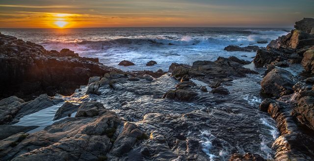 Sunset glows over tide-washed rocks on the Sonoma Coast
